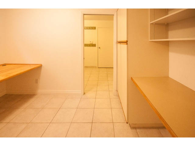 Bright kitchen with wooden countertops and tiled floor. - 4428 Marine Drive, West Vancouver