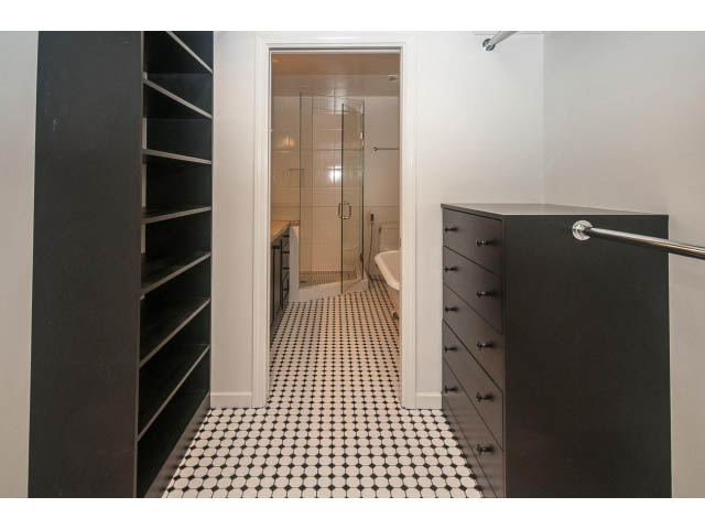 Spacious walk-in closet with black shelving and tiled floor. - 4428 Marine Drive, West Vancouver