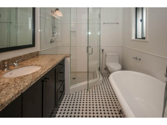 Spacious bathroom with granite countertops and black and white tiled floor. - 4428 Marine Drive, West Vancouver