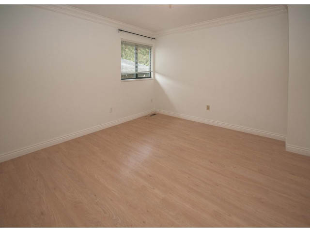 Bright bedroom with hardwood floors and a window view. - 4428 Marine Drive, West Vancouver