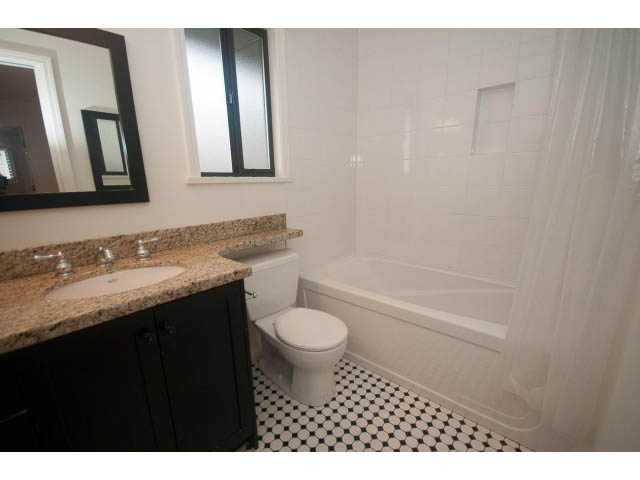 Bright bathroom with granite countertops and black cabinets. - 4428 Marine Drive, West Vancouver