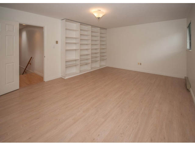 Bright living room with hardwood floors and built-in shelves. - 4428 Marine Drive, West Vancouver