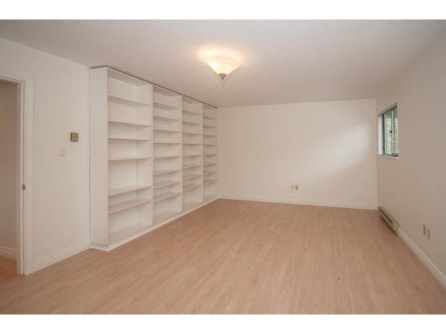 Bright living room with built-in shelves and hardwood floors. - 4428 Marine Drive, West Vancouver