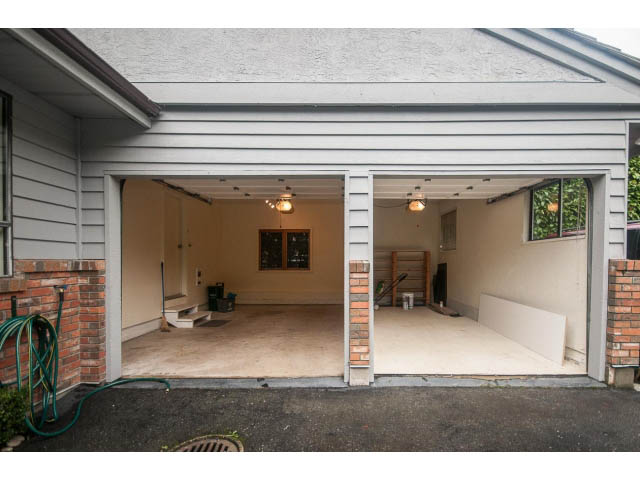 Spacious open-concept garage with exposed brick and modern lighting. - 4428 Marine Drive, West Vancouver