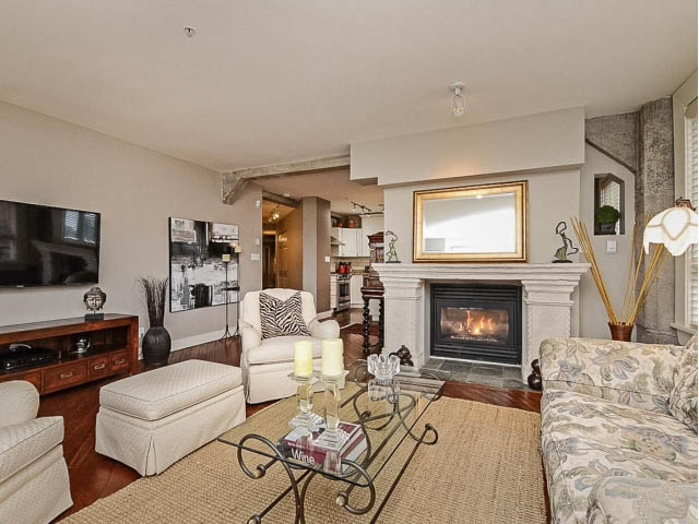 Spacious living room with hardwood floors, large fireplace, and modern decor. - 509 - 1216 Homer Street, Vancouver Downtown