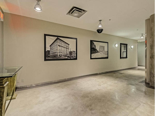 Bright living room with concrete floors, framed architectural photos on walls. - 509 - 1216 Homer Street, Vancouver Downtown