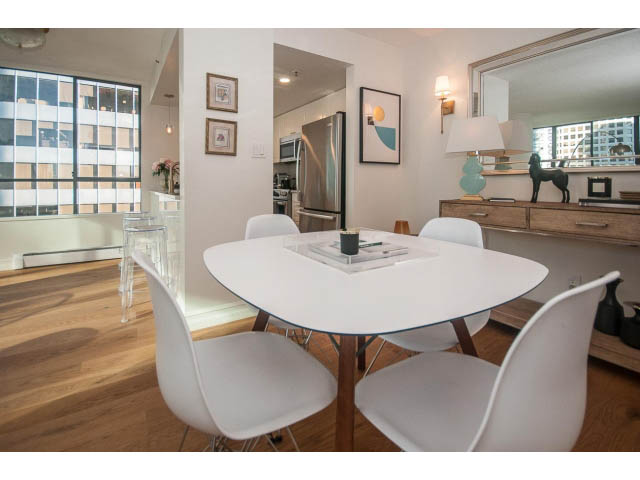 Bright dining area with modern white chairs, hardwood floors, and a city view. - 1406 - 1060 Alberni Street, Vancouver Downtown