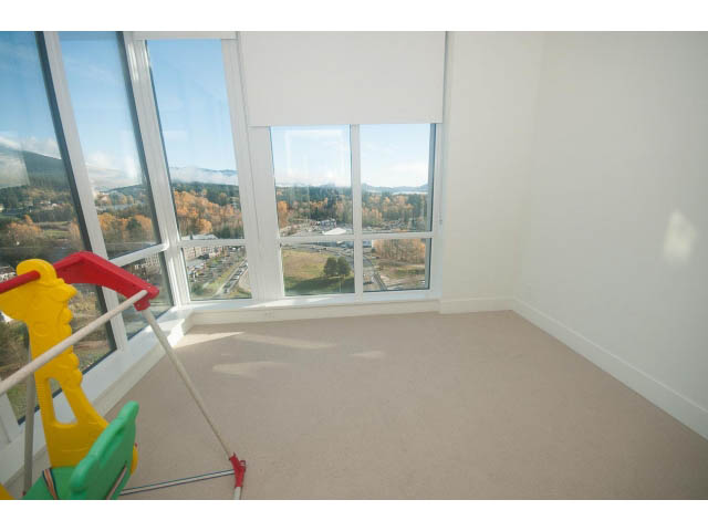 Bright living room with large windows, city view, and cleaning supplies. - 2401 - 1550 Fern Street, North Vancouver