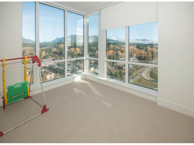 Bright living room with large windows offering a scenic view of the mountains and city. - 2401 - 1550 Fern Street, North Vancouver