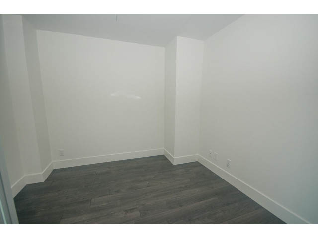 Bright den with hardwood floors and white walls, featuring a built-in bench and countertop. - 2401 - 1550 Fern Street, North Vancouver