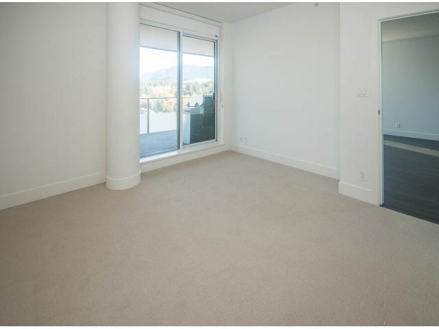 Bright living room with large sliding glass door and city view. - 2401 - 1550 Fern Street, North Vancouver