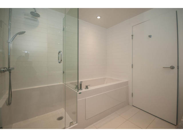 Spacious bathroom with glass shower, modern sink, and white cabinetry. - 2401 - 1550 Fern Street, North Vancouver