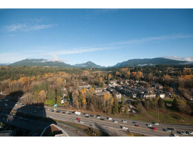 Bright living room with stunning city view and mountain backdrop. - 2401 - 1550 Fern Street, North Vancouver