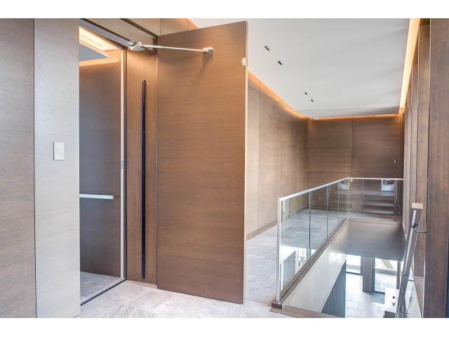 Modern living room with wooden paneling and glass railings. - Address WITHHELD, Burnaby