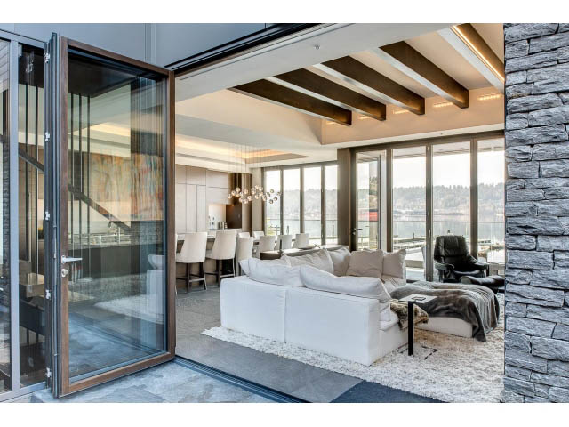 Spacious living room with large windows, stone accents, and a modern design. - Address WITHHELD, Burnaby