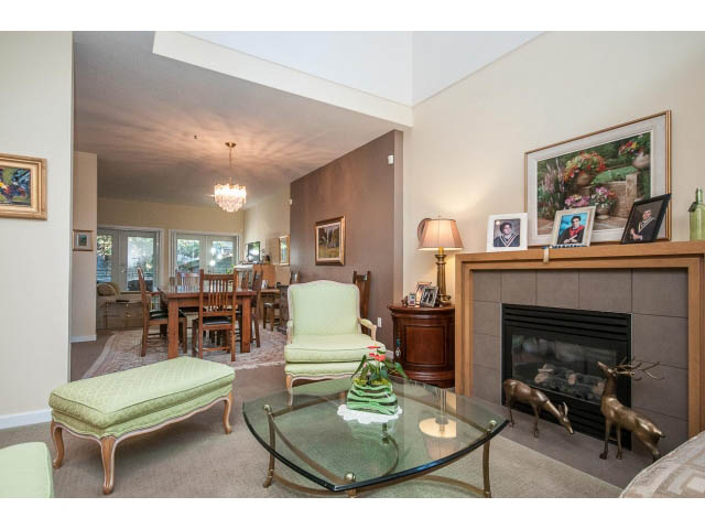 Furnished living room with glass coffee table, green armchair, and deer sculptures. - 17 - 3750 Edgemont Boulevard, North Vancouver
