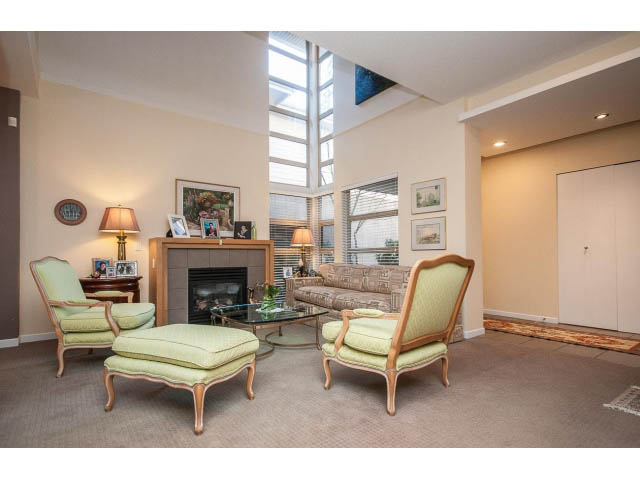 Spacious living room with high ceilings, large windows, and comfortable seating. - 17 - 3750 Edgemont Boulevard, North Vancouver