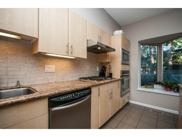 Bright kitchen with granite countertops and stainless steel appliances, offering a modern and functional space.
