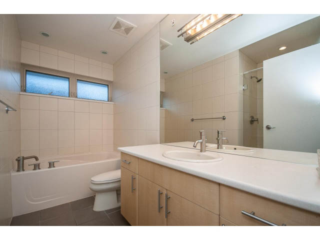 Bright bathroom with light wood cabinets and white countertops. - 17 - 3750 Edgemont Boulevard, North Vancouver