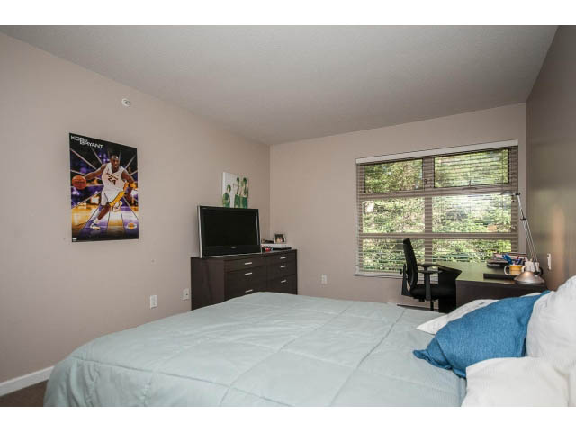 Bright bedroom with large window, hardwood floors, and sports poster on wall. - 17 - 3750 Edgemont Boulevard, North Vancouver