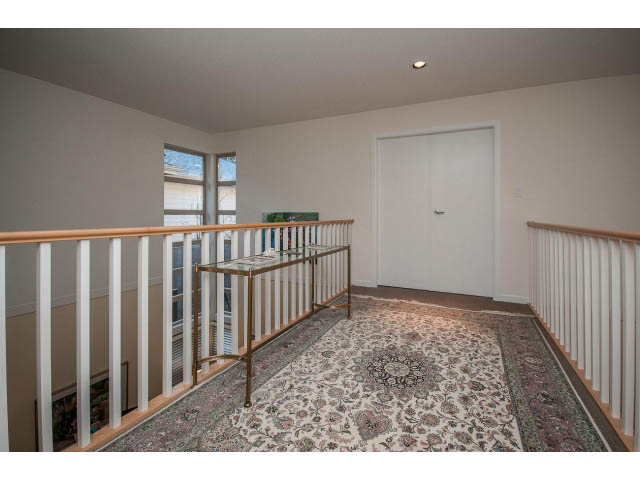 Staircase with ornate carpet and white railings leading to upper level. - 17 - 3750 Edgemont Boulevard, North Vancouver