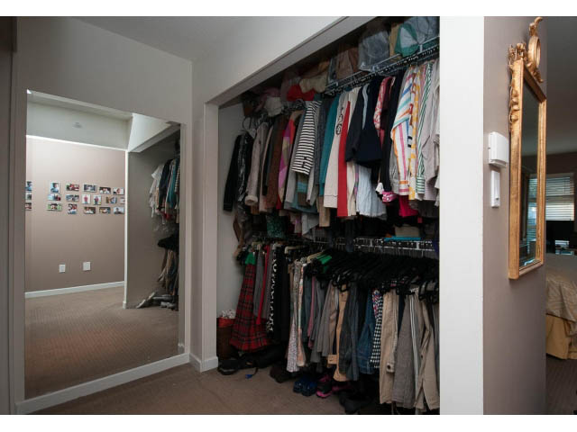 Spacious walk-in closet with neatly organized clothing and large mirror. - 17 - 3750 Edgemont Boulevard, North Vancouver