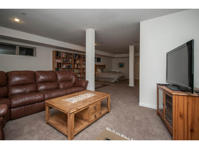 Living room with leather couch, wooden coffee table, and mounted TV. - 17 - 3750 Edgemont Boulevard, North Vancouver