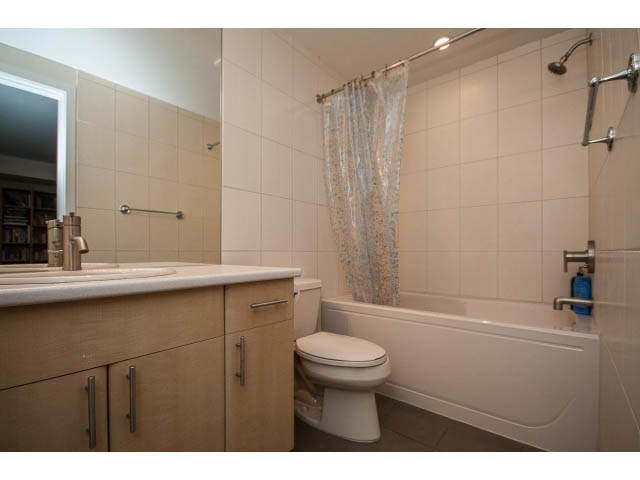 Bright bathroom with beige tiles, countertop, and shower curtain. - 17 - 3750 Edgemont Boulevard, North Vancouver