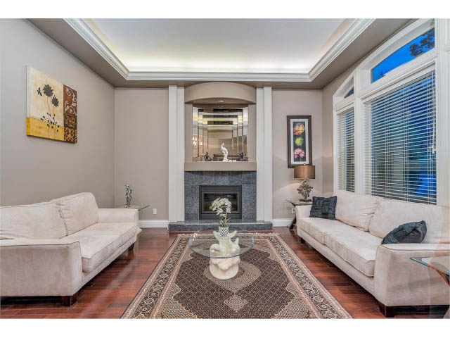 Spacious living room with hardwood floors, modern decor, and large windows. - 4287 Madeley Rd, North Vancouver