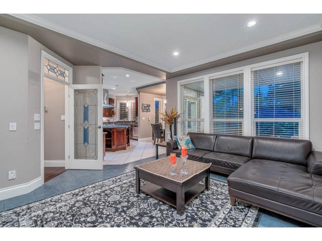 Spacious living room with modern furniture, large windows, and a view of the city. - 4287 Madeley Rd, North Vancouver
