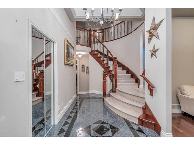 Elegant entryway with marble flooring and wooden staircase leading to upper levels. - 4287 Madeley Rd, North Vancouver