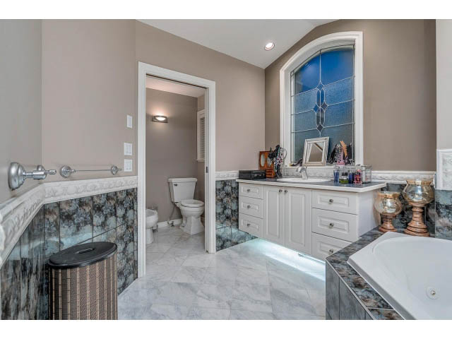 Spacious bathroom with marble countertops and a large window. - 4287 Madeley Rd, North Vancouver