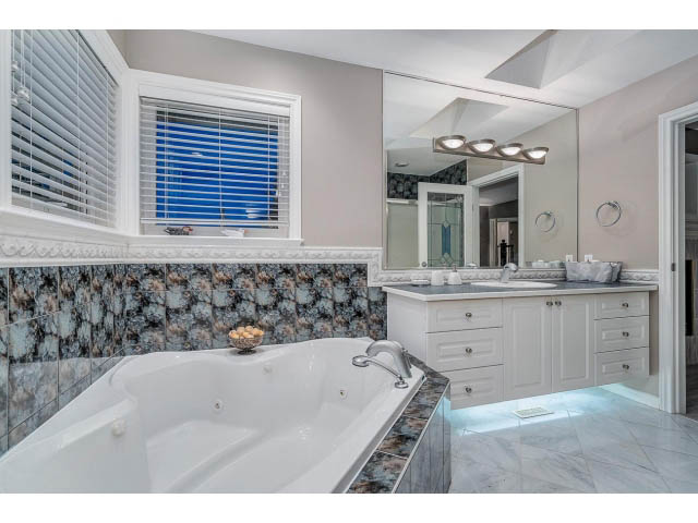 Spacious bathroom with marble countertops and a large soaking tub. - 4287 Madeley Rd, North Vancouver