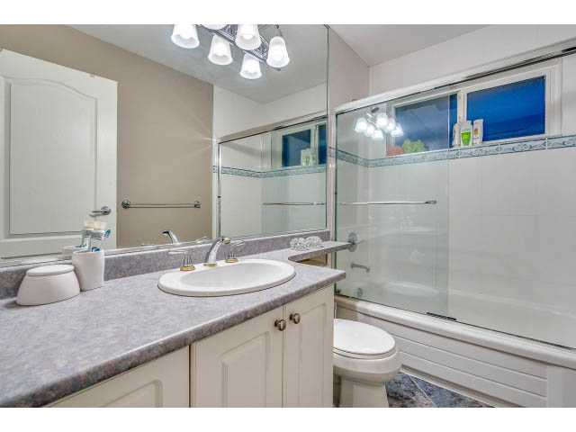Bathroom with granite countertops and a glass shower door. - 4287 Madeley Rd, North Vancouver