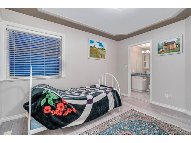 Bright bedroom with checkered bunk beds, hardwood floors, and a view of the kitchen. - 4287 Madeley Rd, North Vancouver