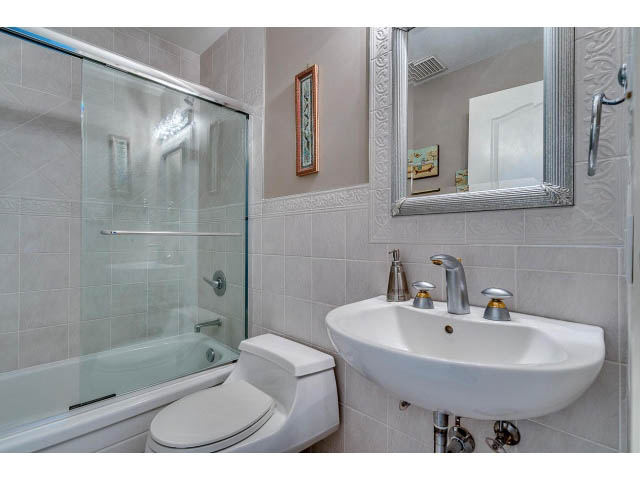 Bathroom with modern sink, glass shower, and large mirror. - 4287 Madeley Rd, North Vancouver