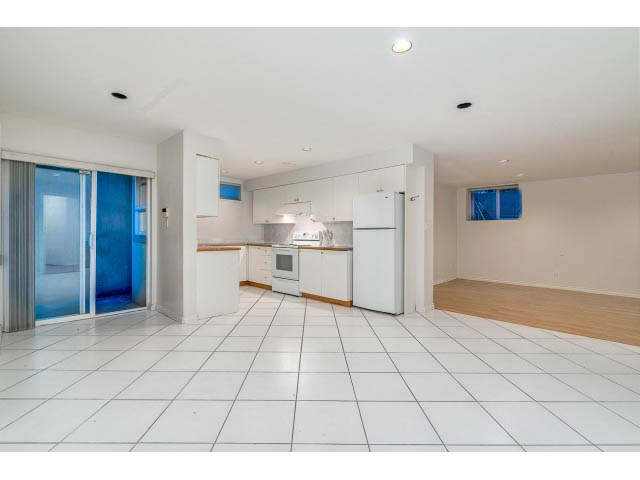 Bright kitchen with white cabinets, hardwood floors, and a city view. - 4287 Madeley Rd, North Vancouver