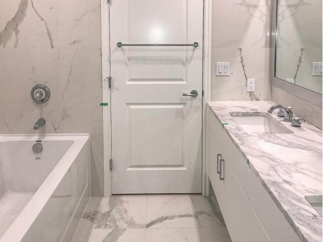 Furnished bathroom with marble countertops and a bathtub. - 105 - 175 Victory Ship Way, North Vancouver