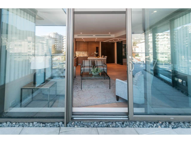 Furnished living room with hardwood floors and city view. - 409 - 1355 Bellevue Ave, West Vancouver