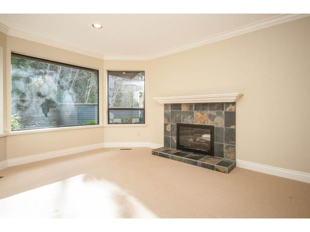 Spacious living room with stone fireplace and large windows. - 5138 Meadfeild Road, West Vancouver