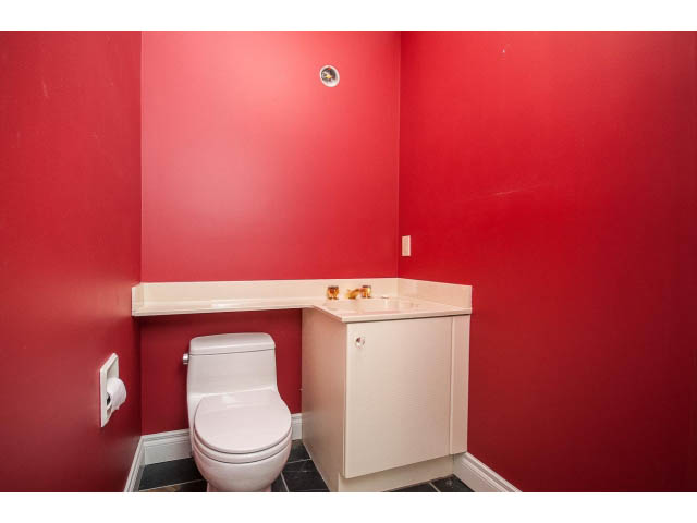 Bathroom with red walls, white toilet, and small countertop. - 5138 Meadfeild Road, West Vancouver