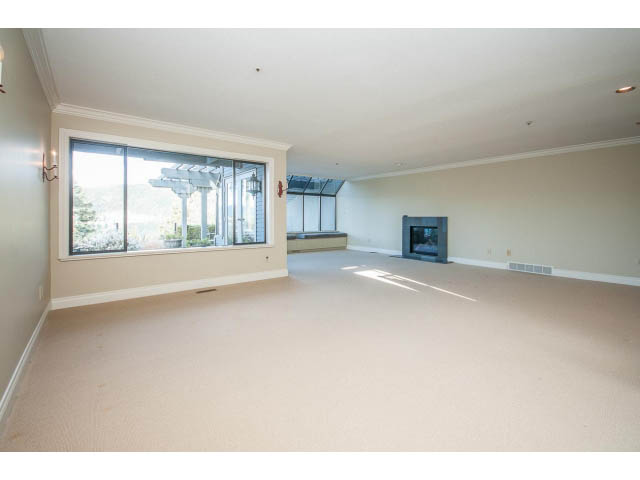 Spacious living room with large windows and neutral walls. - 5138 Meadfeild Road, West Vancouver