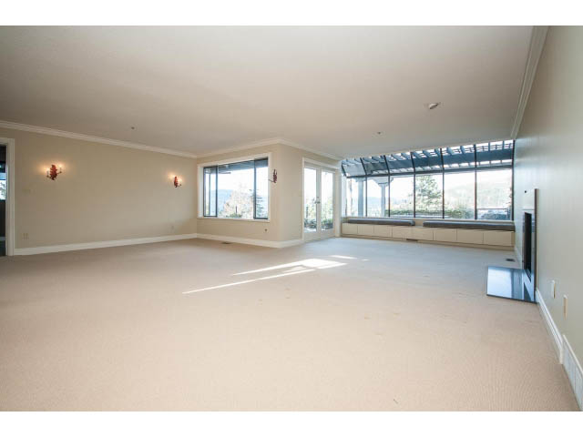 Spacious living room with large windows, natural light, and a view of the mountains. - 5138 Meadfeild Road, West Vancouver