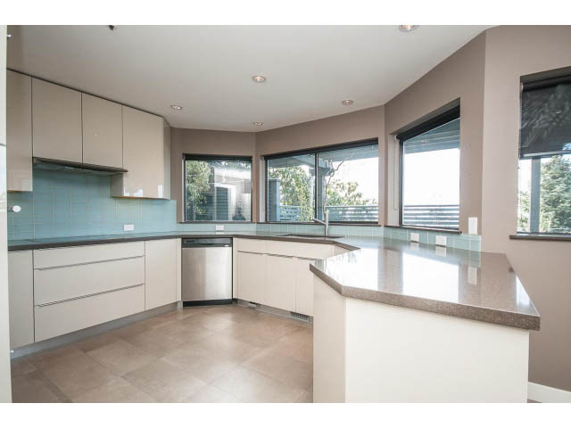 Bright kitchen with modern island, light countertops, and large windows. - 5138 Meadfeild Road, West Vancouver