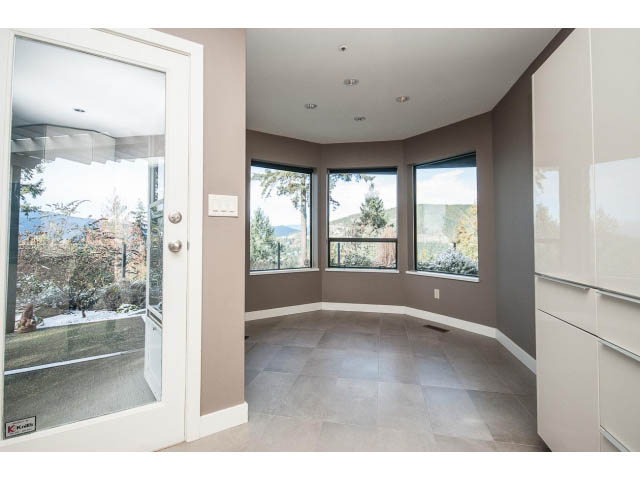 Bright sunroom with large windows, city view, and modern countertops. - 5138 Meadfeild Road, West Vancouver