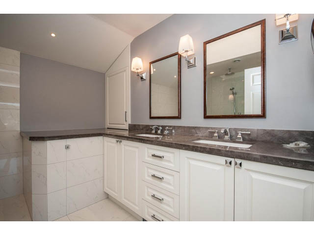 Spacious bathroom with dual vanity, marble countertops, and large mirrors. - 5138 Meadfeild Road, West Vancouver