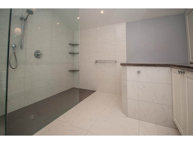 Spacious bathroom with marble countertops and a walk-in shower. - 5138 Meadfeild Road, West Vancouver