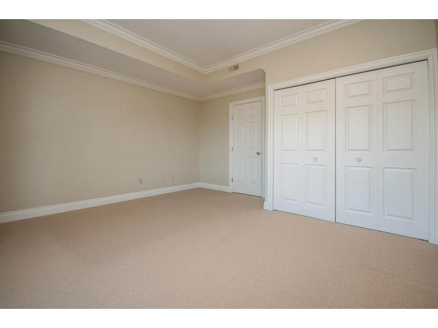 Spacious bedroom with beige walls and carpeted floors. - 5138 Meadfeild Road, West Vancouver