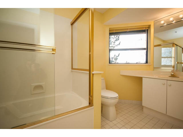Bright bathroom with white countertops and a window view. - 5138 Meadfeild Road, West Vancouver
