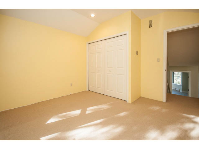 Bright living room with carpeted floors and a sliding closet door. - 5138 Meadfeild Road, West Vancouver